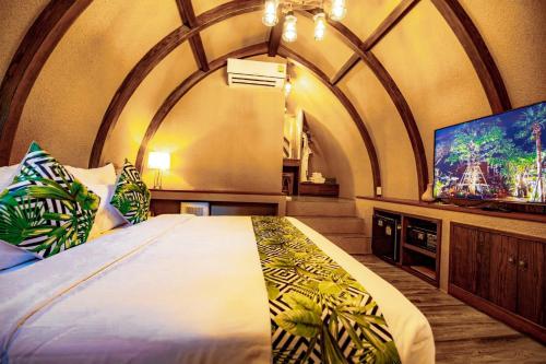 a bedroom with a large bed and a flat screen tv at DAMNERNPAWA in Bang Khon Thi