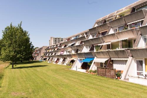 ein Apartmenthaus mit Rasen davor in der Unterkunft Romea in Schilksee