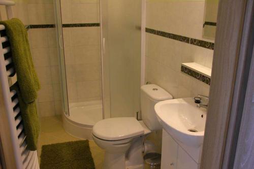 a white bathroom with a toilet and a sink at Złota Rybka Lubniewice in Lubniewice