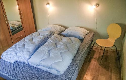 an unmade bed in a room with a chair at Holiday Home Nr Landevej Sydals Xi in Kegnæshøj