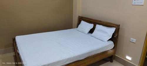 プリーにあるHotel JM International (A Unit of Hotel Care Plaza)のベッド(白いシーツ、枕付)