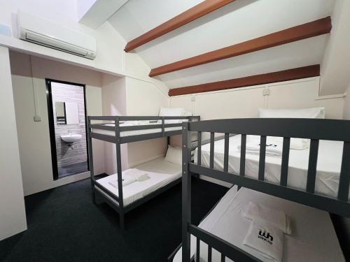 a room with two bunk beds and a bathroom at Wink at Perak Road in Singapore