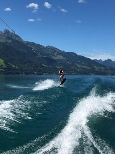 a man riding a wave on a surfboard in the water at Resort Walensee 45 in Unterterzen