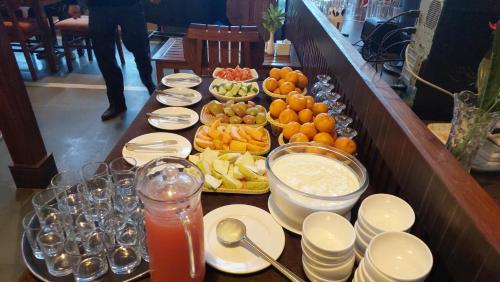 a buffet with plates and bowls of fruit and drinks at Royal Tiger Luxury Resort in Sauraha