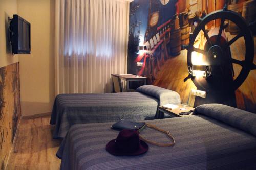 a hotel room with two beds and a hat on the bed at Hostal 4C Cuatro Caminos in Madrid