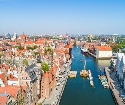 a view of a city with boats in a river at Hostel Gdańsk Szafarnia 10 Old Town in Gdańsk