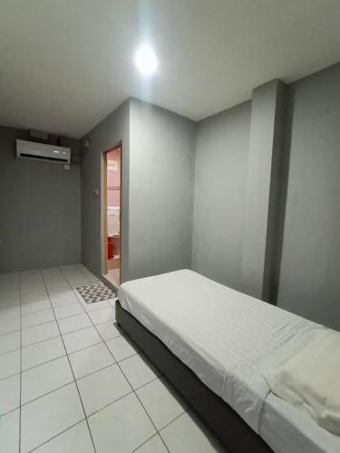 a bedroom with a large bed and a tiled floor at Hotel Iramanis in Lahad Datu