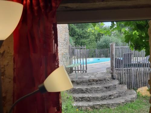 モンティニャックにあるLe Chai, gîte de charme avec piscineの窓(ランプ付)とプールが備わる客室です。