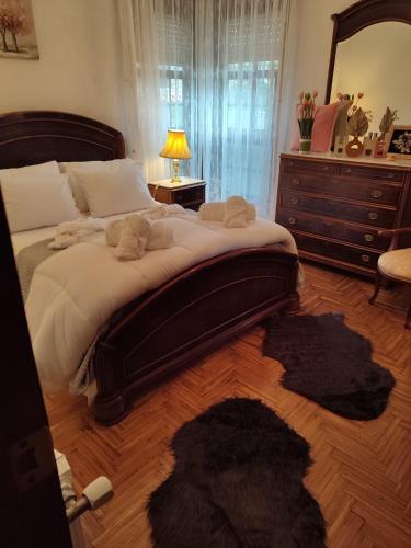 a bedroom with a large bed with a dresser and a mirror at Casa da Rapadoira in Laxoso de Abaixo