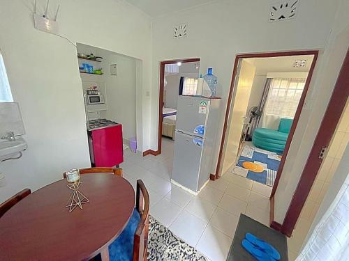 eine Küche und ein Esszimmer mit einem Tisch und einem Kühlschrank in der Unterkunft Homely apt 1 (one) in Kisumu