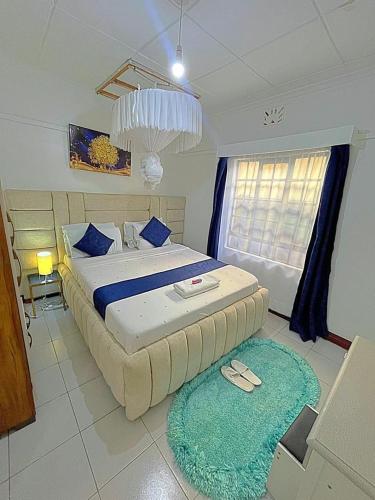a bedroom with a large bed with blue pillows at Homely apt 1 (one) in Kisumu