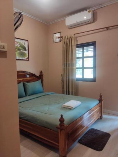 a bedroom with a bed and a window at Erawan Guesthouse in Pakse