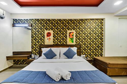 a bedroom with a bed with two towels on it at Krushnai Resort in Lonavala
