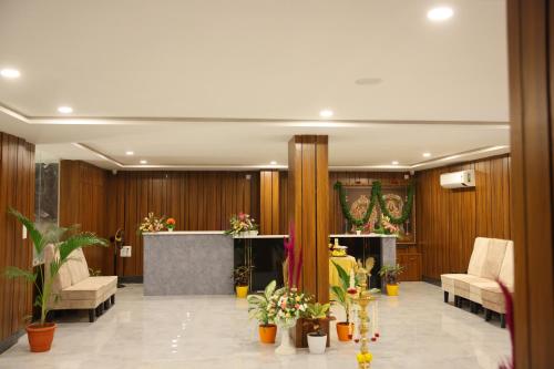 a lobby with chairs and plants in a building at HOTEL GRAND ORCHID in Tirupati
