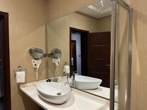 uma casa de banho com um lavatório e um espelho em Rich Bridge Hotel em Abuja