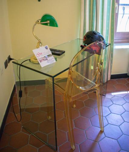a glass desk with a lamp and a helmet on it at Da Gin in Castelbianco