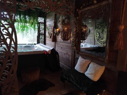 ein Zimmer mit Badewanne und Spiegel in der Unterkunft SIANDAKI NID D AMOUR AVEC JACUZZI in La Motte