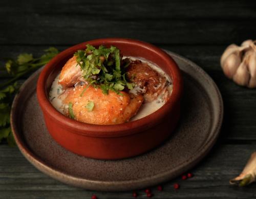a red bowl filled with food on a plate at VinoOdor - ვინოოდორ in Tʼelavi