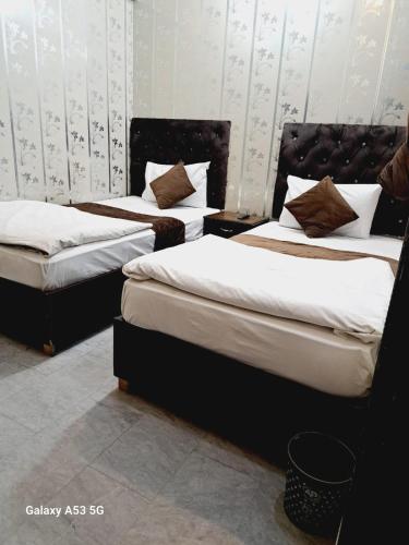 two beds in a room with two bedsskirts at Lord Family Hotel in Lahore