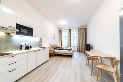 una cucina e un soggiorno con tavolo e divano di Apartments Borivojova 63 a Praga