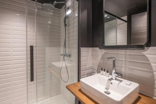 W łazience znajduje się umywalka i prysznic. w obiekcie Appart'hôtel East Paris Suite w Paryżu