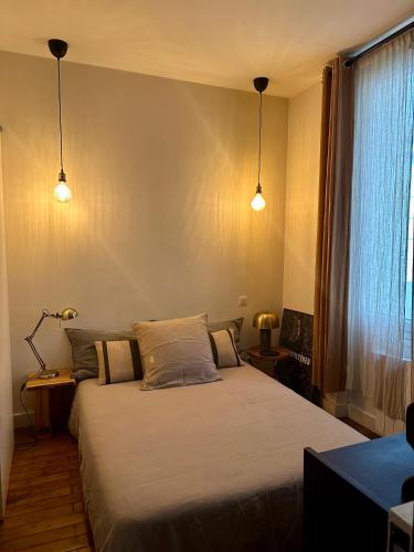 a bedroom with two beds and two lights at Appartement Cosy Paris Montmartre in Paris