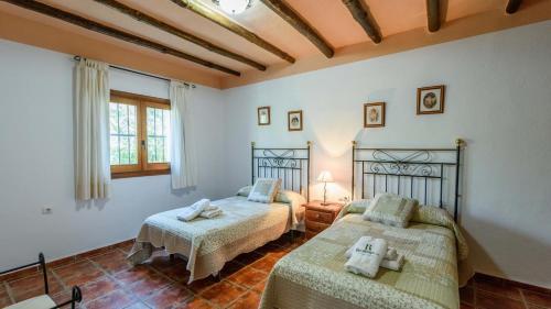 een slaapkamer met 2 bedden in een kamer bij Cortijo Molino Benizalte Orgiva by Ruralidays in Órgiva