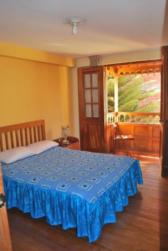 a bedroom with a blue bed with a window at Hospedaje Kamila in Cusco