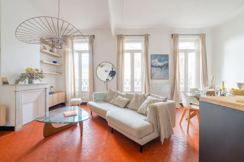 un salon avec un canapé et une table en verre dans l'établissement Appartement de charme au cœur de la plaine by Weekome, à Marseille