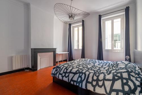 une chambre avec un lit et un lustre dans l'établissement Appartement de charme au cœur de la plaine by Weekome, à Marseille
