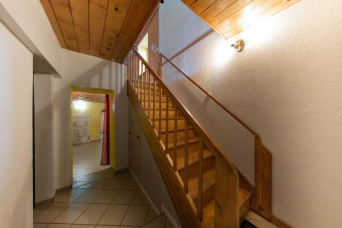 a hallway with a wooden staircase in a house at Le Domaine du Verger gîtes et SPA in Osenbach