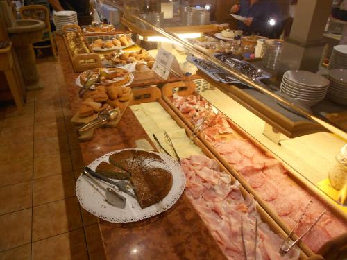 a buffet line with a chocolate cake and other pastries at Hotel San Marco in Passo San Pellegrino