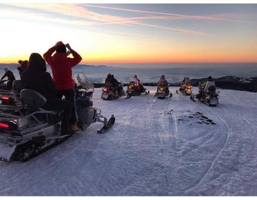 a group of people riding on snowobiles in the snow at The Post Stana de Vale in Stana de Vale
