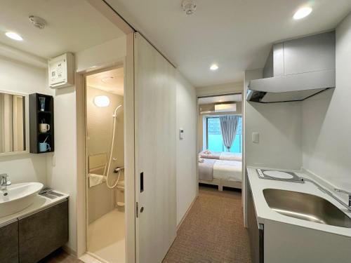 a bathroom with a sink and a toilet and a bed at Hoshino Stay 2 Near Namba 3-Min Walk to Station in Osaka