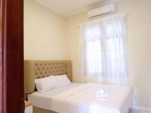 a bedroom with a bed with two white towels on it at Singgah Tentrem Homestay - Yogyakarta in Salakan
