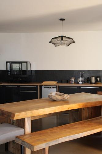 a wooden table in a kitchen with a light fixture at Casa Santa Lucia in Bocognano