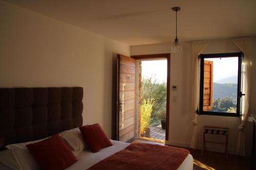 a bedroom with a bed and a large window at Casa Santa Lucia in Bocognano