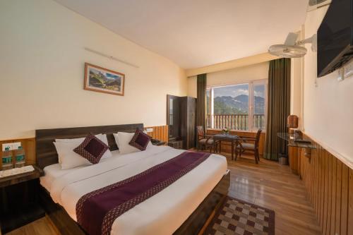 Habitación de hotel con cama grande y balcón. en Seven Hills Shimla by Him Haults Hospitality en Shimla