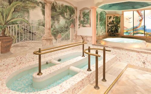 a jacuzzi tub in a room with a painting at Hotel Eberl in Finkenberg