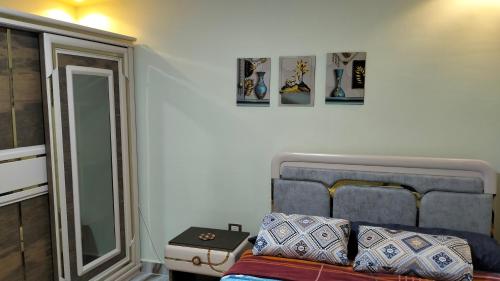 a bedroom with a blue couch and some pictures on the wall at Flores casas de playa in Alexandria