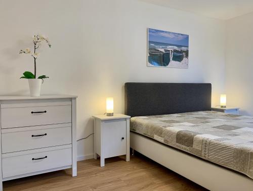 ein Schlafzimmer mit einem Bett und einer Kommode mit zwei Lampen in der Unterkunft Ferienhaus Hete in Staphel