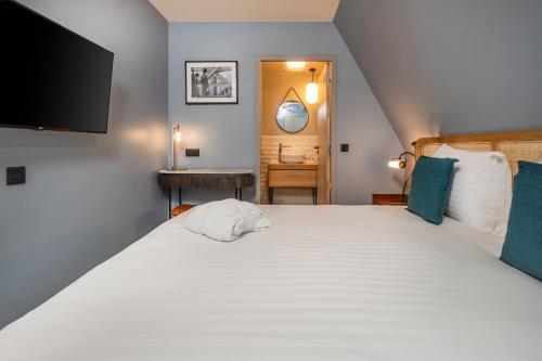 sypialnia z dużym białym łóżkiem i telewizorem z płaskim ekranem w obiekcie Appart'hôtel East Paris Suite w Paryżu