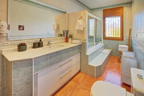 a bathroom with a sink and a shower and a toilet at VILLA ARBUCIES with private pool in Lloret de Mar