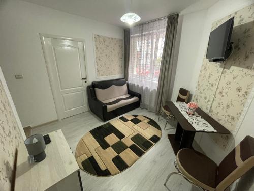 a small living room with a chair and a table at R.M Apartament in Lugoj