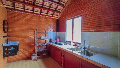 a kitchen with a sink and a brick wall at homstay Hương Rừng in Tân Phú