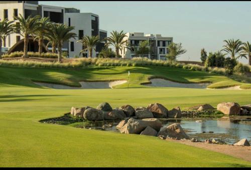 a golf course at the resort with a hole and rocks at The Oasis Luxury Apartment in Aqaba