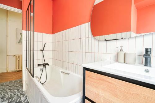 une salle de bain avec une baignoire et un lavabo dans l'établissement Apartment next to Palais des Congrès - Neuilly - II, à Neuilly-sur-Seine