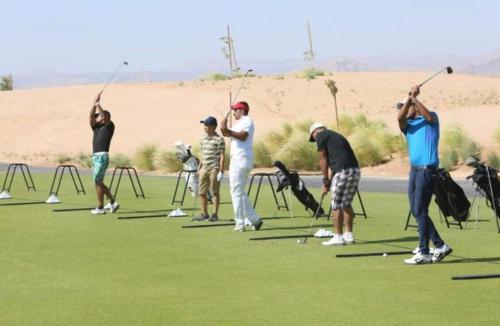 a group of people playing golf on a golf course at The Oasis Luxury Apartment in Aqaba