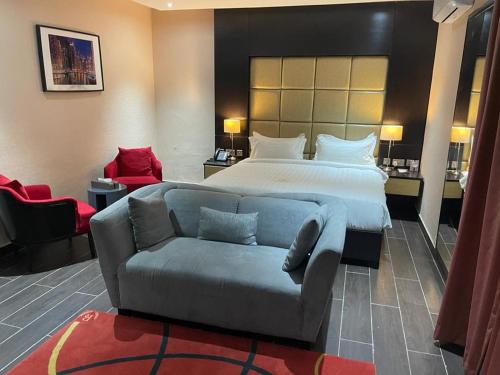 um quarto de hotel com uma cama e um sofá em Rich Bridge Hotel em Abuja