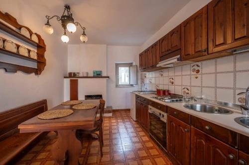 eine Küche mit Holzschränken, einem Tisch und einer Spüle in der Unterkunft La torretta sul cortile in Monteroduni